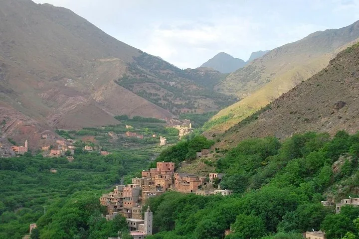 Dorfgebäude, verstreut entlang eines üppig grünen Tals im Toubkal-Nationalpark