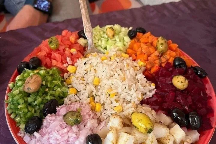 Colourful plate of salad ingredients including rice, tomatoes, cucumbers, and beetroot