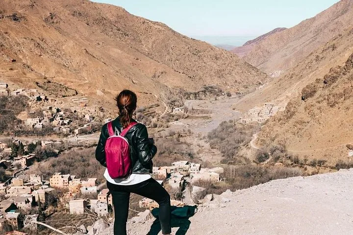 Mujer mirando hacia abajo a un pueblo en un valle, Parque Nacional de Toubkal